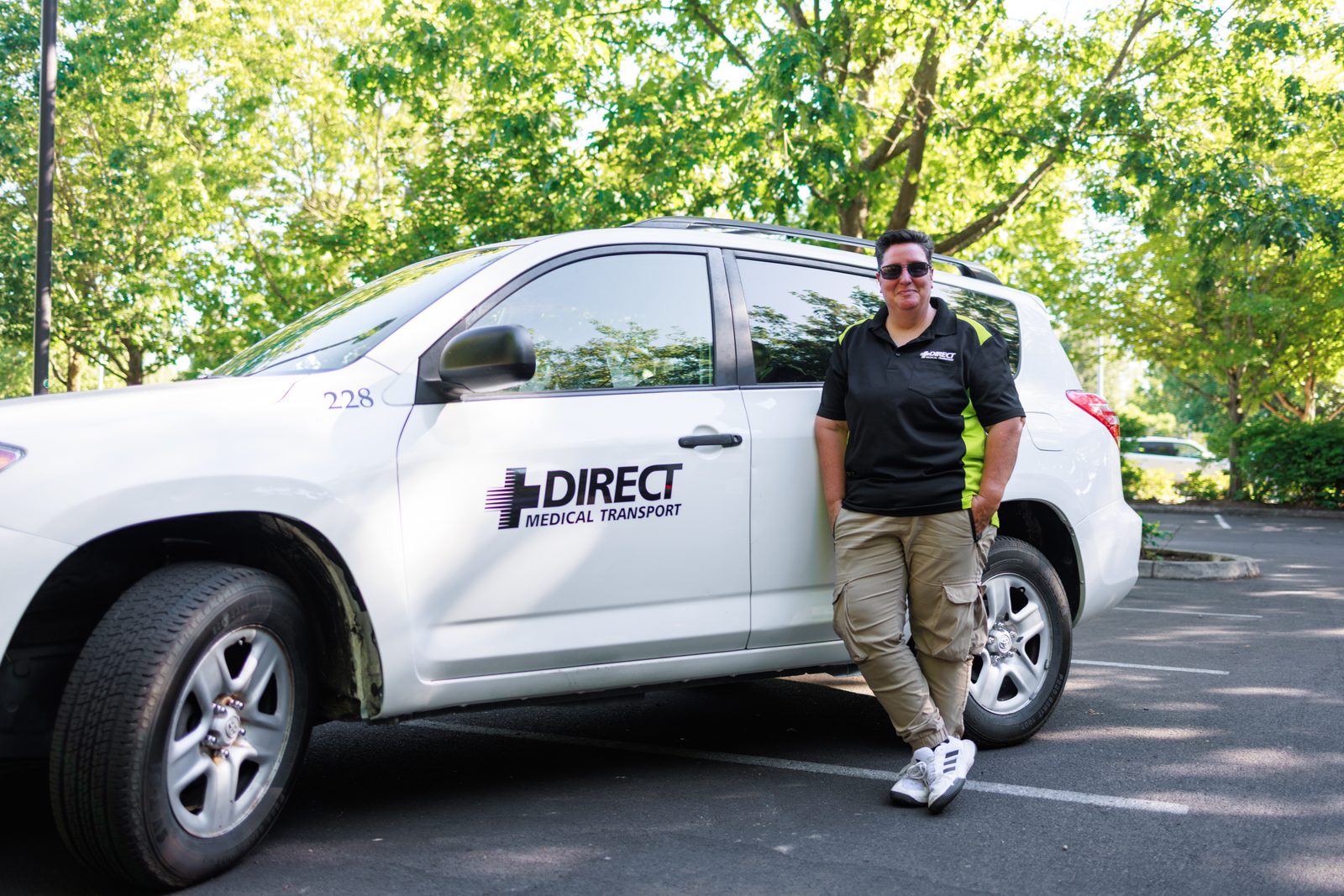Direct Medical transportation driver beside a marked ambulatory medical transportation vehicle in Eugene, Oregon
